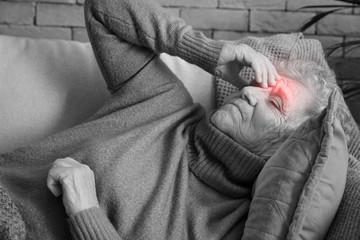 Senior woman suffering from headache at home
