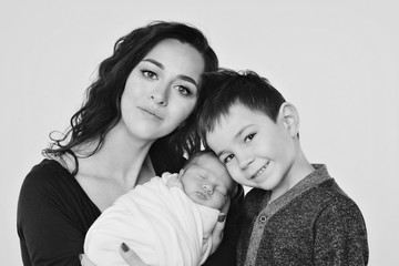 Fototapeta premium family photo on a white background: woman and boy spend time with children. hug the baby. the concept of childhood, fatherhood, motherhood, IVF