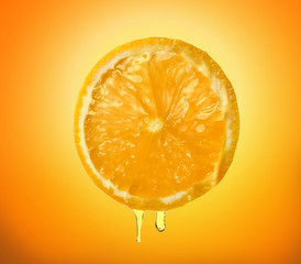 Essential oil dripping from orange slice on white background