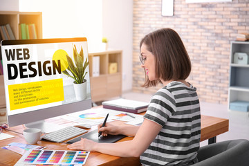Beautiful young designer working in office