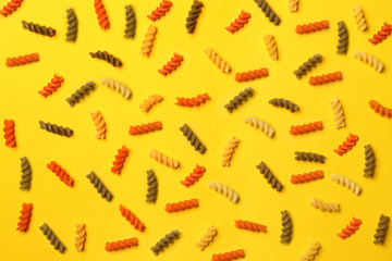 Uncooked fusilli pasta on color background