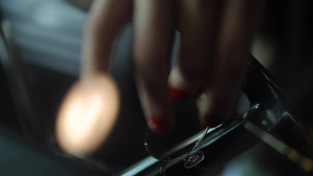 Women holding classes while resting her hand on the steering wheel.