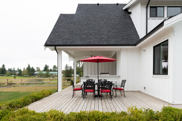 Red patio set at a modern white farmhouse in suburban North America