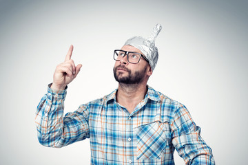 Bearded funny man in a cap of aluminum foil. Concept art phobias
