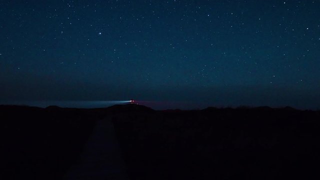 Night sky above Amrum and the North Sea with lighthouse / Timelapse