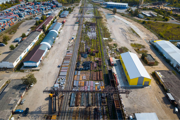 Top view of the industrial zone: railway rails, garages, warehouses, containers for storing goods. The concept of storage of goods by importers, exporters, wholesalers, transport enterprises, customs