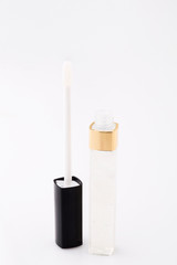 translucent lip gloss brush and bottle on background