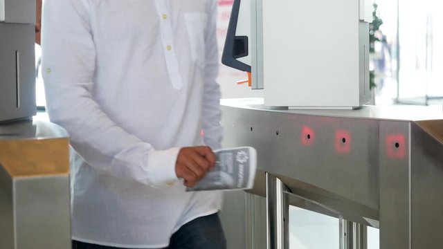 Modern electronic entrance in the business building, technology background. Media. A man in white shirt scanning his ticket and passing through.
