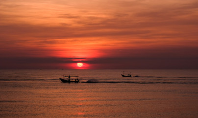 Naklejka premium sunset on the sea with fishing boat thailand