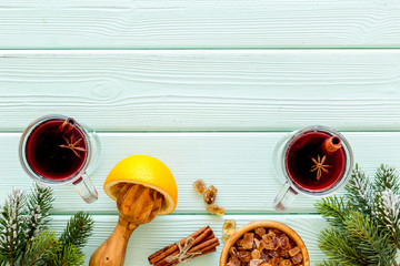 Mulled wine and fir branches frame on green wooden background top view copy space