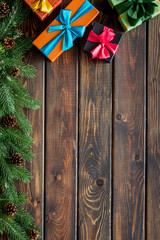 Presents for christmas in boxes and spruce frame on wooden background top veiw copyspace