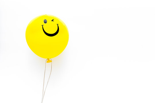 Happiness emotion. Yellow balloon with smile on white background top view copy space