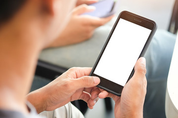 Cropped shot view of man hands holding smart phone with blank copy space screen for your text message or information content, female reading text message on cell telephone during in urban setting. 
