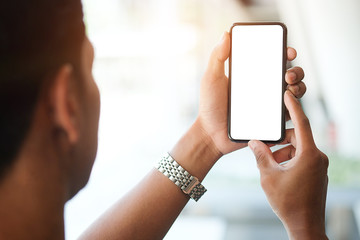 Cropped shot view of man hands holding smart phone with blank copy space screen for your text message or information content, female reading text message on cell telephone during in urban setting. 