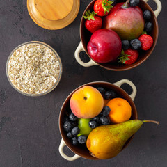 Raw cereals with fruit on a dark background top view