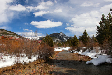 Colorado snowy early spring beautiful nature background. Scenic view with water stream on a covered by snow valley between rocky mountains. Amazing Keystone landscape, Colorado, USA.