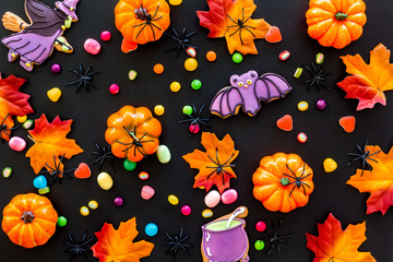 Nice halloween background with sweets. Cookies and pumpkins on black top view pattern