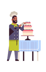 male professional chef pastry cook decorating tasty wedding cream cake african american man restaurant worker in uniform cooking food concept flat full length vertical