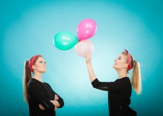 Retro girls preparing balloons birthday party.