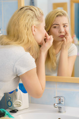 Woman looking at her skin in mirror