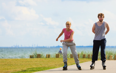 Teen couple together on skates.