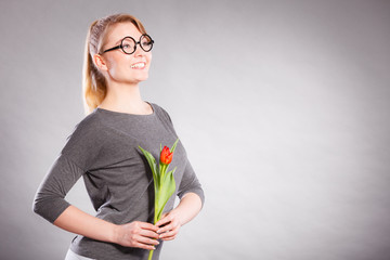 Happy blonde woman with spring flower.