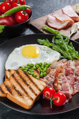 Fried eggs with bacon and vegetables