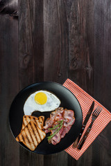 Fried eggs with bacon and vegetables