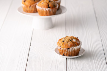 Blueberry muffins with white table place setting.