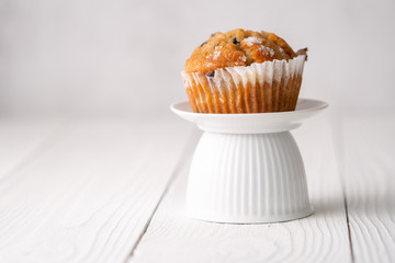 Blueberry muffins with white table place setting.