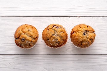 Blueberry muffins with white table place setting.