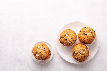 Blueberry muffins with white table place setting.