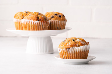 Blueberry muffins with white table place setting.