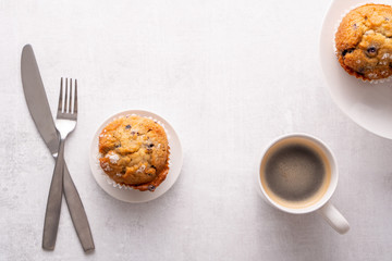 Blueberry muffins with white table place setting.