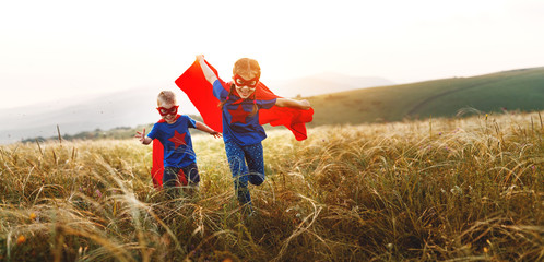 happy children boy and girl in costumes of superheroes in outdoor