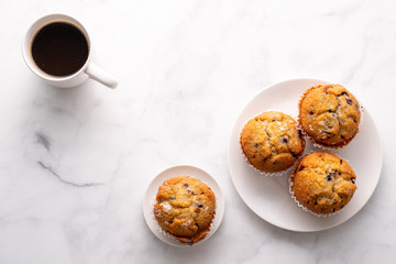 Blueberry muffins with white table place setting.