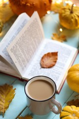 Autumn books. Tea mug, open book, set of pumpkins with a  garland on a blue wooden...