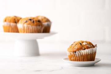 Blueberry muffins with white table place setting.