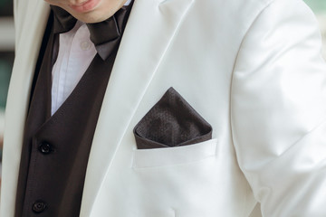 A handkerchief in a white suit of a man