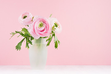 Summer pink decor for home with buttercup flowers - pastel bouquet in exquisite glass vase on white wood table, soft light background.