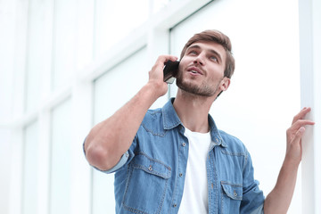 young man talking on the phone standing in office