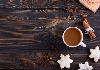 Christmas gingerbread cookies on a wooden background with aromatic coffee and cinnamon sticks