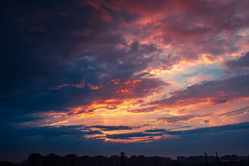 pink cloudy sky during sunset with urban building silhouettes.
