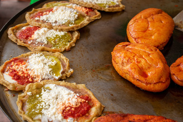 Comida mexicana: comal con sopes con queso y salsa picante, más pambazos. Son antojitos, usualmente comida callejera