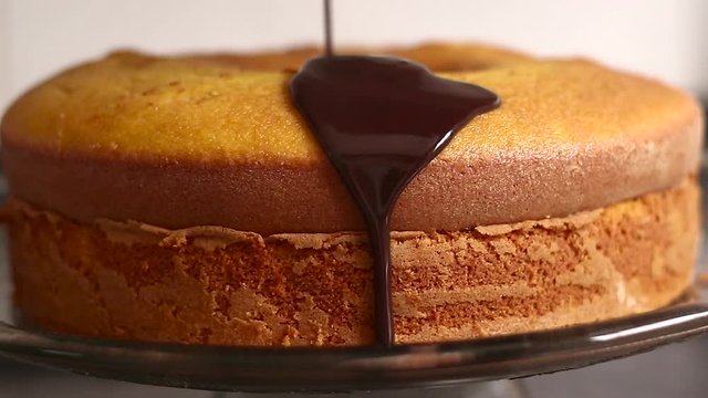 Chocolate icing on carrot cake. Chocolate glaze pouring on homemade cake. Brazilian carrot cake. Topping chocolate on carrot cake. June Partys sweet