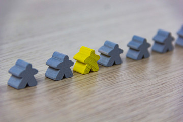 Gray gaming pieces and a black meeple, diversity concept