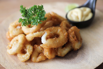 Caramari , Appetizer Crispy fried squid ring with tartar sauce on wood background traditional italian food