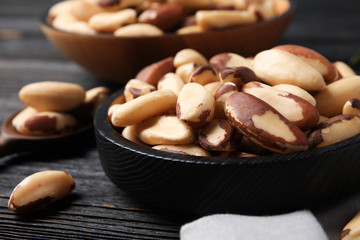 Plate with tasty Brazil nuts on wooden table