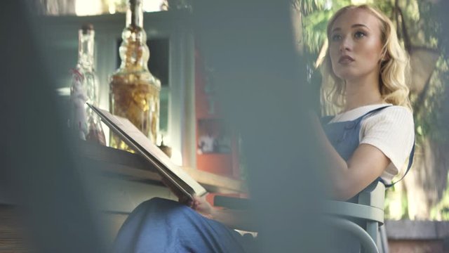 Pensive beautiful woman looking deep and sitting in a bar stool with the menu lying on her knees, leasure concept. Art. Portrait of a caucasian woman in a casual outfit of sitting at a bar.