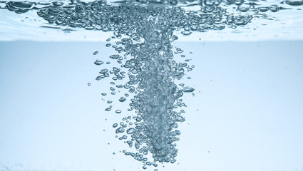 Fresh water with bubbles against blue background